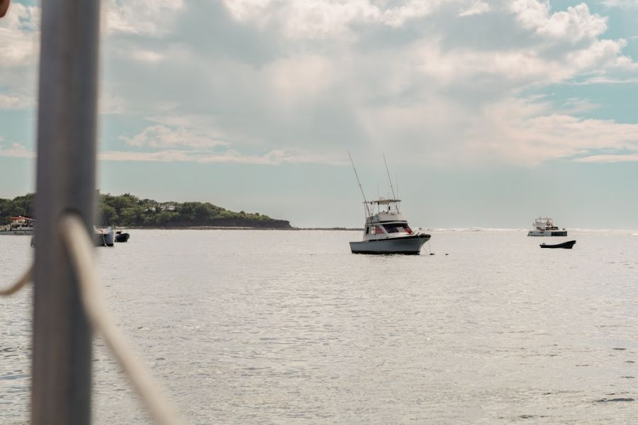Boats on calm sea near distant island