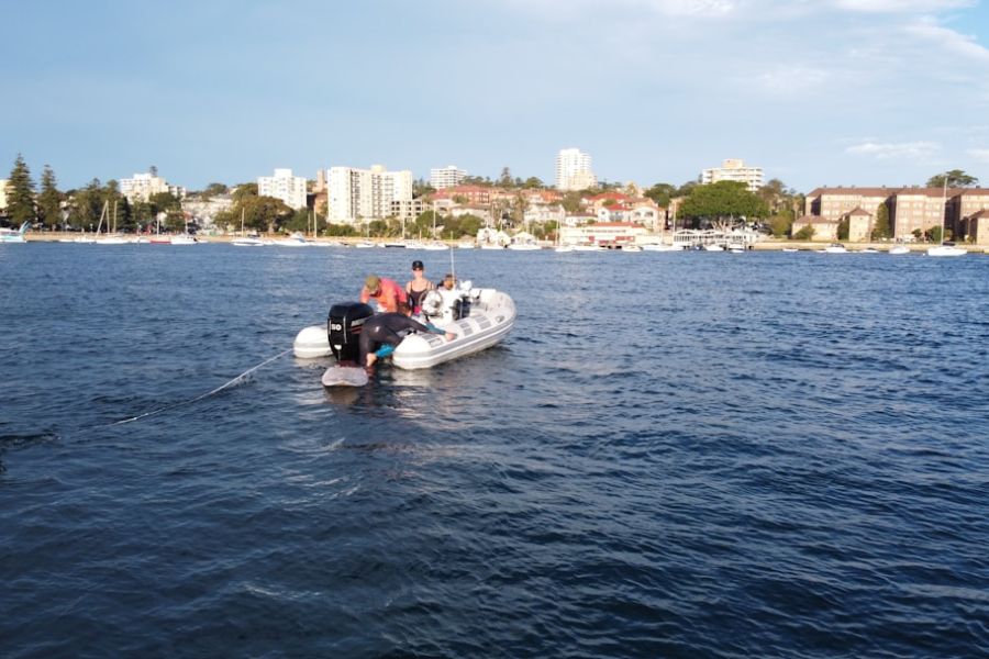 People on inflatable boat near city shoreline