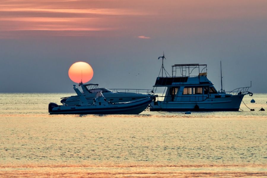 Sunset over two anchored boats on calm water