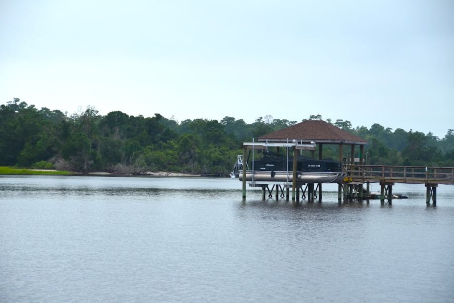 Pontoon boat docked at wooden pier.