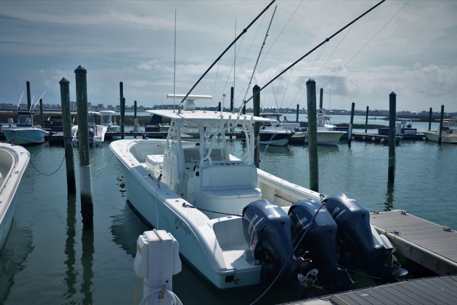 White center-console fishing boat at dock.