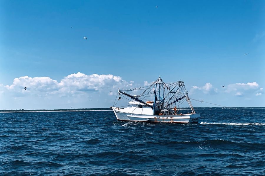 Fishing boat on blue ocean with rigging