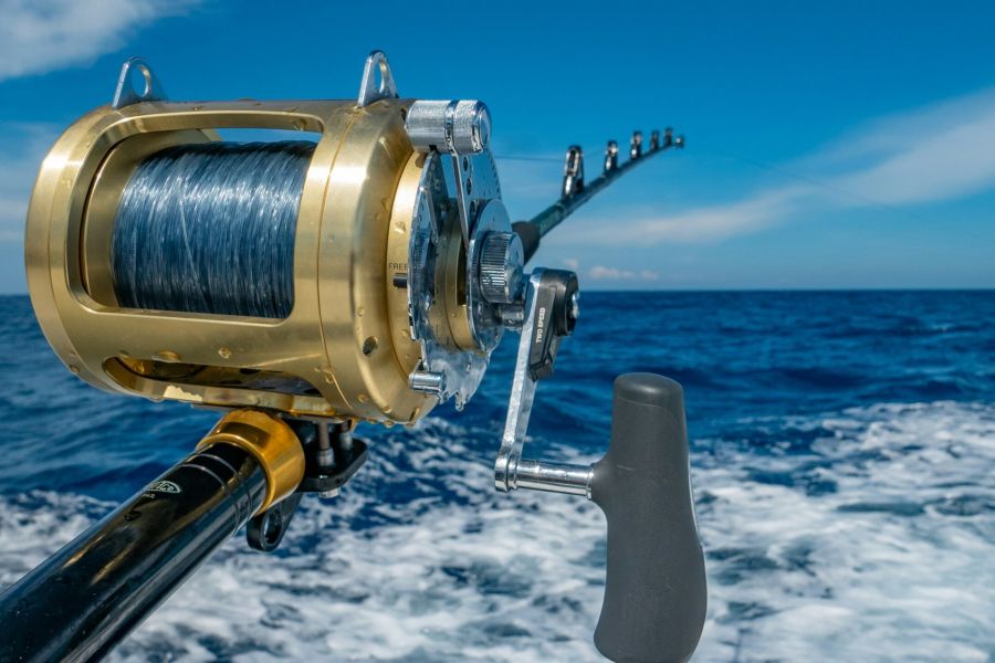 Brass fishing reel mounted on rod at sea