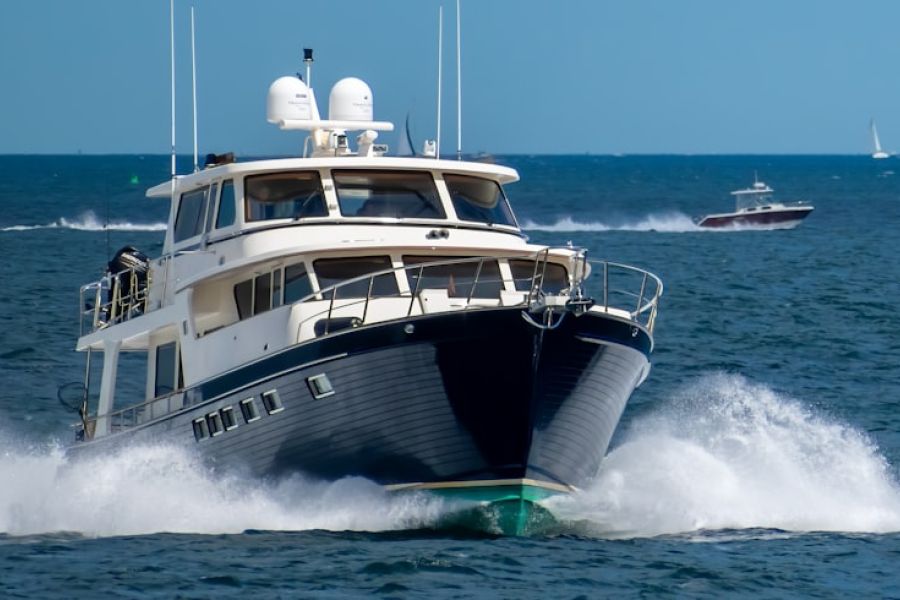 White and navy yacht cutting through waves