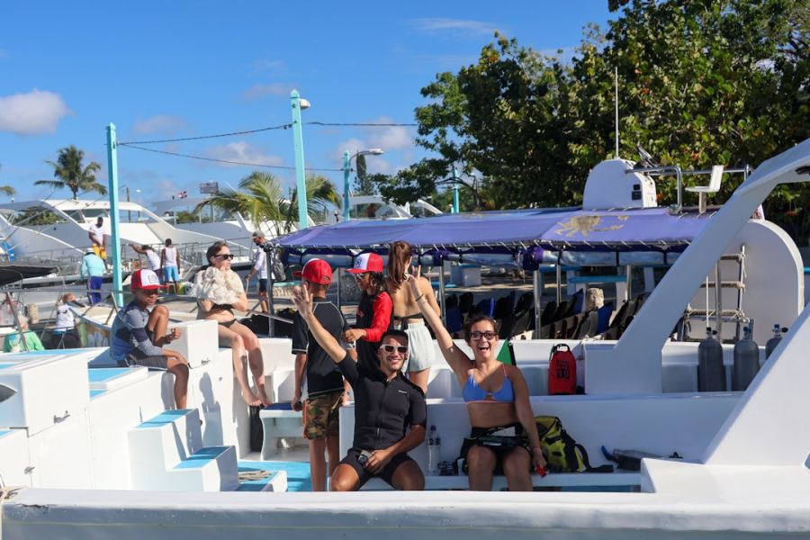 Smiling group on white boat under blue sky