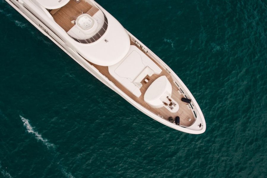 Top-down view of white yacht on teal water