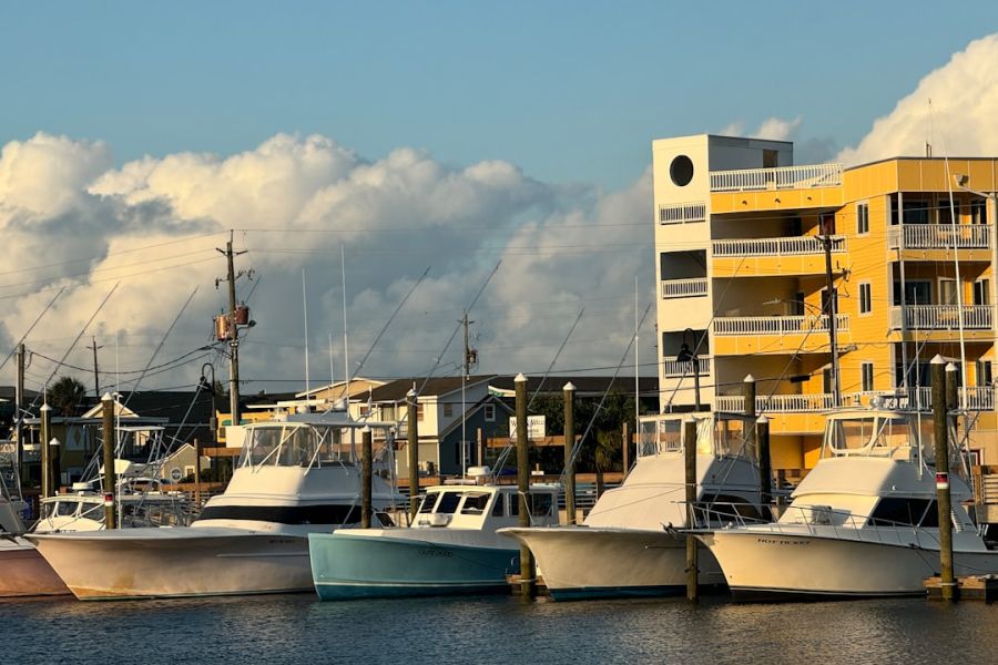 Boats moored at marina beside yellow building