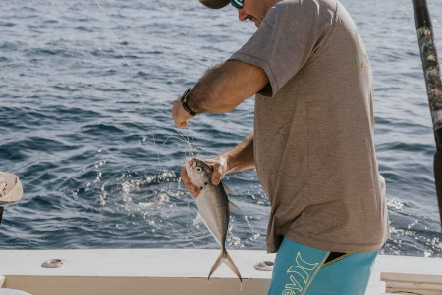 Angler on a boat catching small fish.