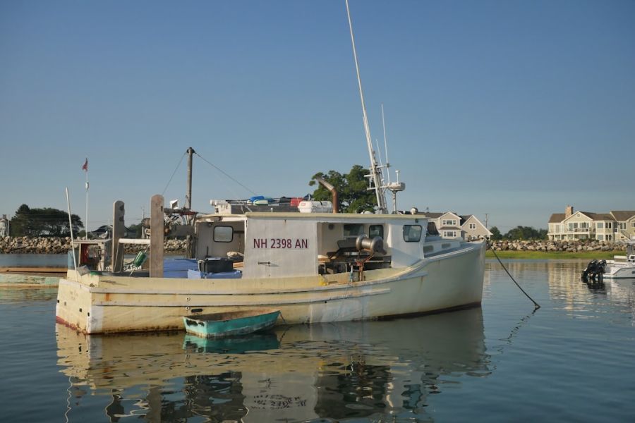 Docked fishing boat on calm harbor water.