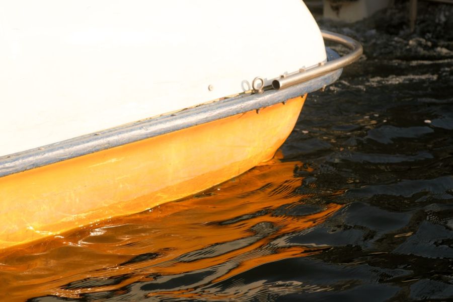 Orange boat hull beside dark water.
