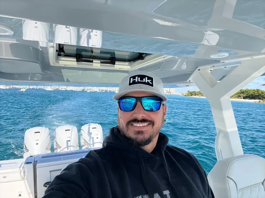 Man on boat wearing HUK cap and sunglasses
