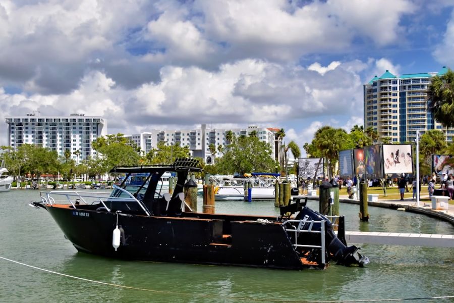Damaged black boat docked at the marina