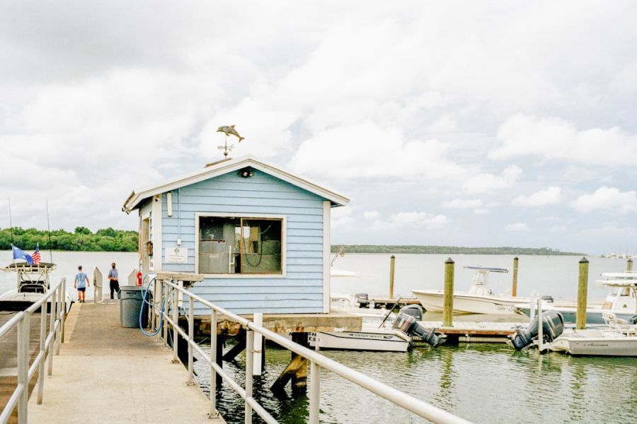 Blue boathouse on dock near water