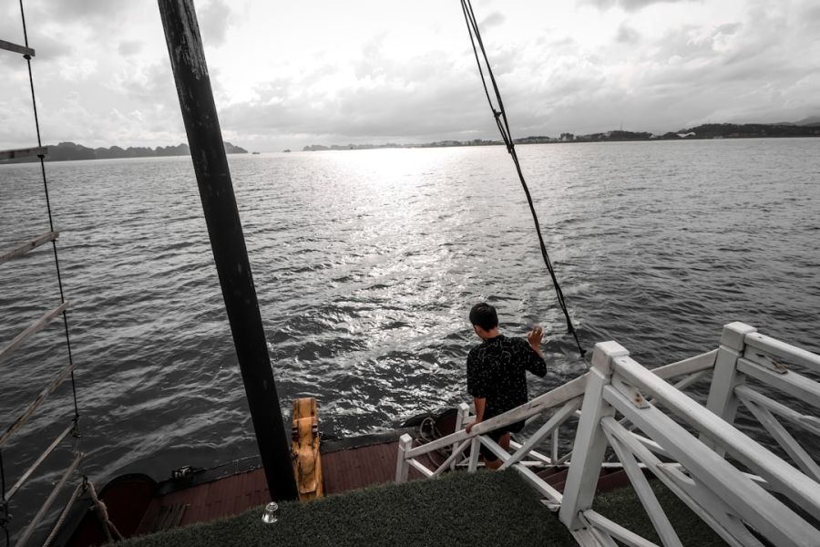 Person standing on boat deck near railing.