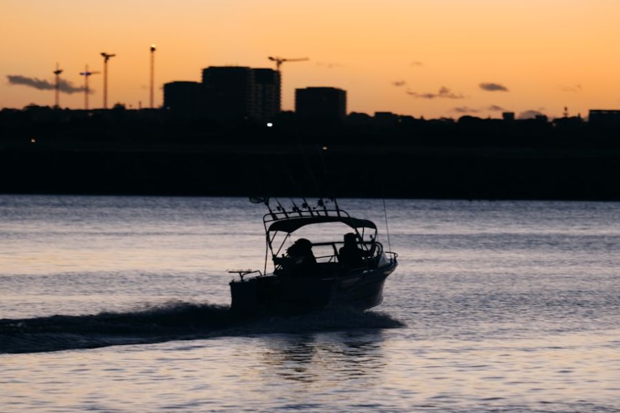 Silhouetted boat on water at sunset