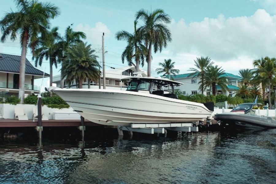 Yacht docked along canal with palm trees