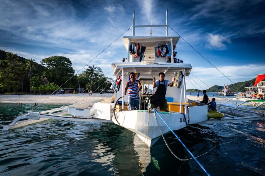 People aboard a white boat near shore.